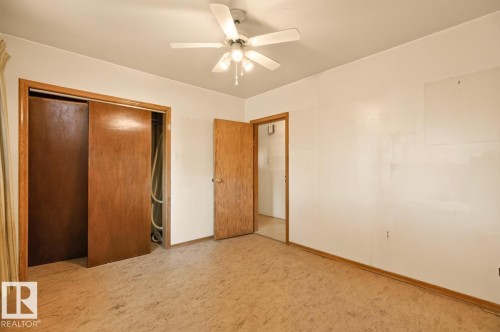 Ceiling fan with integrated lighting, wood-finish flooring, wood-finish doors, and white walls - 12309 128 Street Nw, Edmonton, AB 