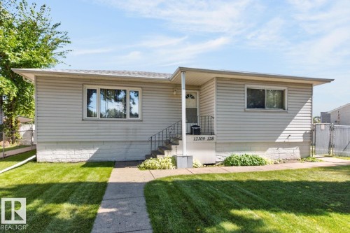 Light-colored siding exterior with a concrete walkway leading to the front entry - 12309 128 Street Nw, Edmonton, AB 