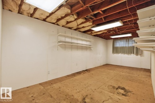 Unfinished space featuring exposed ceiling joists, white paneled walls, and built-in shelving - 12309 128 Street Nw, Edmonton, AB 