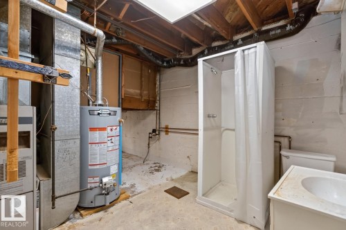 Utility area featuring a water heater, furnace, freestanding shower, toilet, and vanity sink - 12309 128 Street Nw, Edmonton, AB 