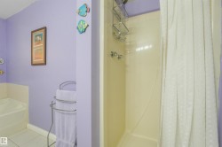 Bathroom featuring a built-in shower stall with chrome fixtures and a separate built-in bathtub - 