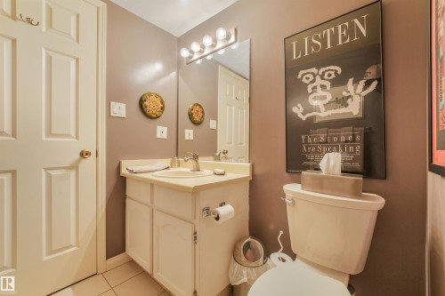 Bathroom featuring a single vanity with a laminate countertop, a rectangular mirror, and an overhead vanity light fixture - #203 10171 119 St Nw, Edmonton, AB 