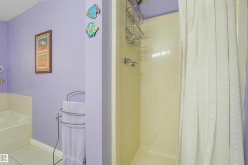 Bathroom featuring a built-in shower stall with chrome fixtures and a separate built-in bathtub - #203 10171 119 St Nw, Edmonton, AB 