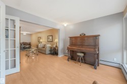 Light wood-finish flooring throughout, framed doorway, and white French doors - 