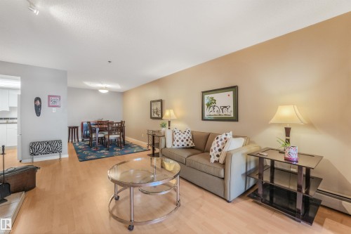 Light wood-finish flooring throughout, smooth ceilings, and warm-toned wall paint - #203 10171 119 St Nw, Edmonton, AB 