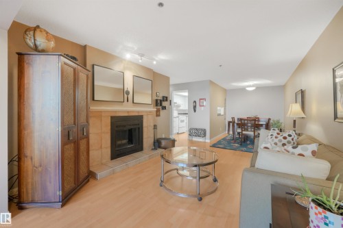 Tiled fireplace with a wood mantle - #203 10171 119 St Nw, Edmonton, AB 