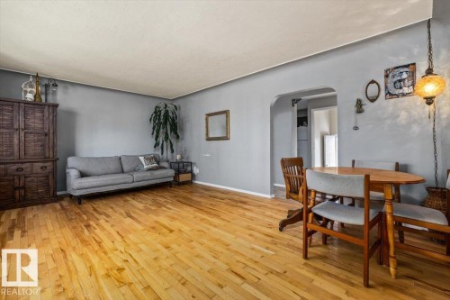 Hardwood flooring throughout, a wide arched doorway, and a ceiling-mounted light fixture - 10990 135 Street Nw, Edmonton, AB 