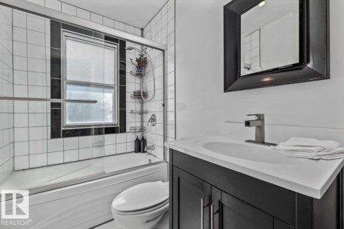 Modern bathroom featuring a sleek vanity with white quartz countertop, matte black hardware, and integrated sink - 10990 135 Street Nw, Edmonton, AB 