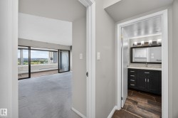 Hallway between the front entry, bedroom, storage, and bathroom space. - 