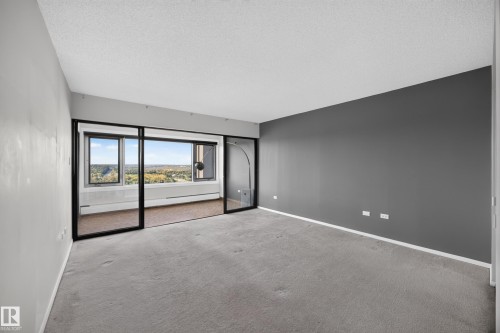 Large bedroom featuring double sliding doors leading to flex space with large south facing windows and stunning views of the River Valley. - #803 10011 123 St Nw, Edmonton, AB 