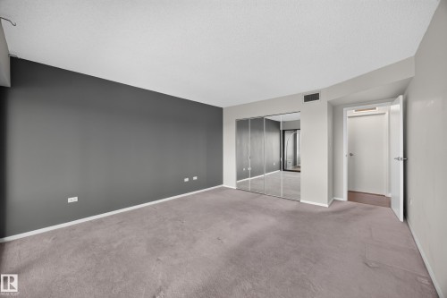 Large bedroom featuring double sliding doors leading to flex space with large south facing windows and stunning views of the River Valley. - #803 10011 123 St Nw, Edmonton, AB 