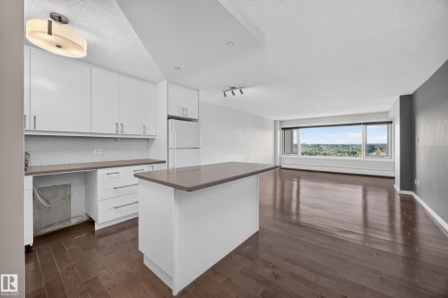 White kitchen featuring quartz counters, hardwood flooring, electric stove, microwave hood fan, space for a dishwasher, and refrigerator. - #803 10011 123 St Nw, Edmonton, AB 