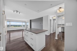 White kitchen featuring quartz counters, hardwood flooring, electric stove, microwave hood fan, space for a dishwasher, and refrigerator. - 