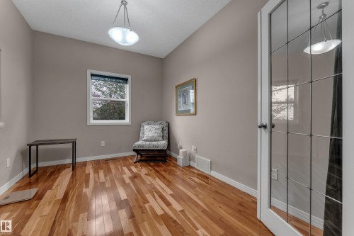 Hardwood flooring, painted walls, window with blind, glass-paneled door, and overhead lighting - 1226 Mcallister Way Sw, Edmonton, AB 