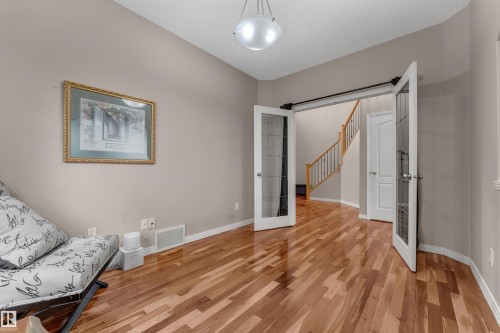 Wood-finish flooring throughout, paired with neutral wall tones - 1226 Mcallister Way Sw, Edmonton, AB 