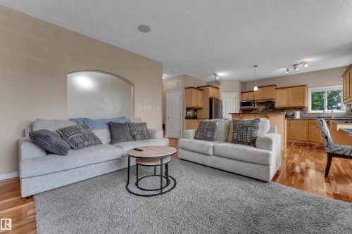 Hardwood flooring, recessed lighting, kitchen with wood cabinetry, stainless steel appliances, and a built-in microwave - 1226 Mcallister Way Sw, Edmonton, AB 