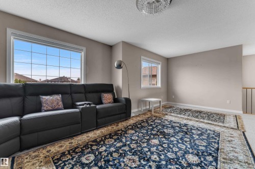 Spacious room featuring multiple windows, neutral wall tones, and a coffered ceiling - 1226 Mcallister Way Sw, Edmonton, AB 