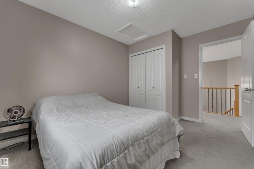 Light gray carpeting, neutral wall tones, and white bifold closet doors - 1226 Mcallister Way Sw, Edmonton, AB 