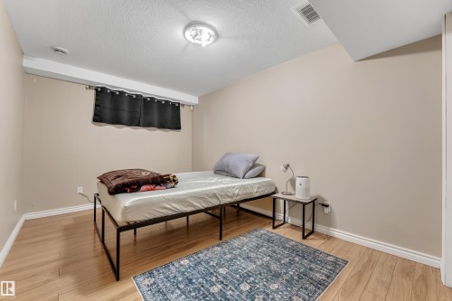Wood-finish flooring with white trim, complemented by a flush-mount ceiling light - 1226 Mcallister Way Sw, Edmonton, AB 