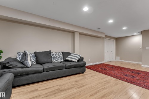 Recessed lighting, wood-finish flooring, neutral wall tones, and white bi-fold closet doors - 1226 Mcallister Way Sw, Edmonton, AB 