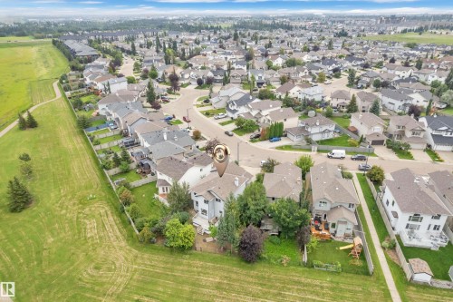 Expansive residential community featuring detached homes with varied architectural styles, individual fenced yards, and a developed streetscape - 1226 Mcallister Way Sw, Edmonton, AB 
