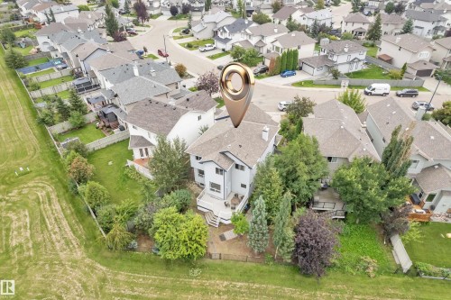 Rear elevation with a multi-level deck, mature landscaping, and a fenced yard - 1226 Mcallister Way Sw, Edmonton, AB 