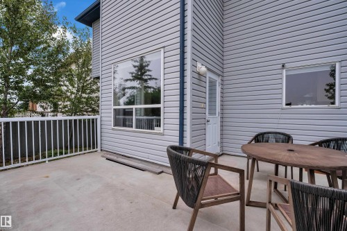 Spacious outdoor deck with a white railing, featuring horizontal siding and multiple windows - 1226 Mcallister Way Sw, Edmonton, AB 
