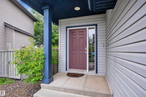 Concrete entry steps leading to a covered porch with a dark blue support column and coordinating ceiling - 1226 Mcallister Way Sw, Edmonton, AB 