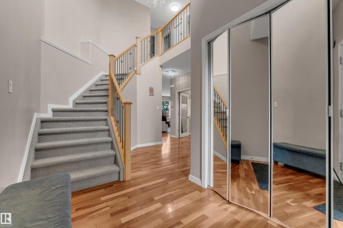 Wood-finish flooring with a carpeted staircase and wood newel posts - 1226 Mcallister Way Sw, Edmonton, AB 