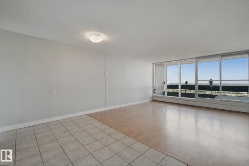 Expansive windows, wood-finish flooring, tiled flooring, neutral wall tones, and ceiling-mounted light fixture - #104 8745 165 St Nw, Edmonton, AB 