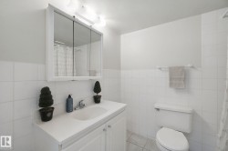 White tile-surround bath with a built-in vanity, medicine cabinet, and overhead light fixture - 