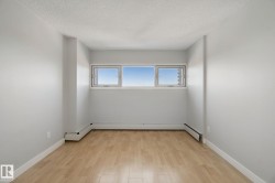 Light wood-finish flooring, white walls, and a multi-pane window - 