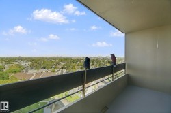 Balcony with a solid railing, concrete flooring, and a wide-ranging cityscape in the distance - 
