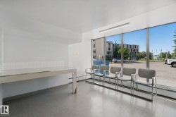 Expansive windows providing abundant natural light, a long built-in counter with a tiled backsplash, and recessed overhead lighting - 