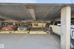 Concrete parking garage with marked parking spaces and concrete support columns - 