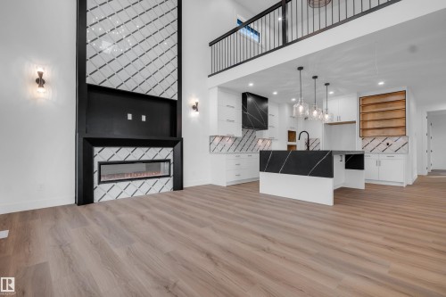 Open-concept living area featuring a floor-to-ceiling fireplace with an electric insert and intricate tile detailing - 57 Meadowgrove Lane, Spruce Grove, AB - Indoor