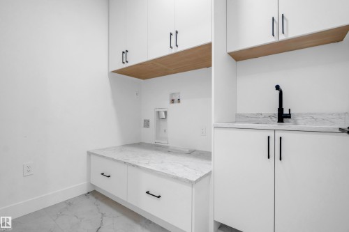 Laundry space featuring white cabinetry, light wood-finish shelving, and white countertops - 57 Meadowgrove Lane, Spruce Grove, AB - Indoor