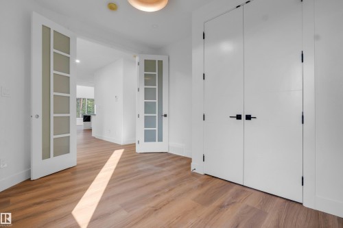 Spacious interior with wood-finish flooring, white walls, and contemporary baseboards - 57 Meadowgrove Lane, Spruce Grove, AB - Indoor Photo Showing Other Room