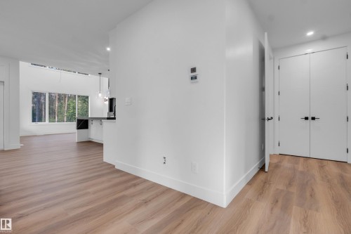 Open-concept area featuring wide plank wood-finish flooring, white walls, recessed lighting, and expansive windows - 57 Meadowgrove Lane, Spruce Grove, AB - Indoor Photo Showing Other Room