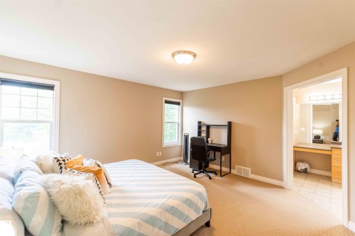 Carpeted bedroom with two windows and neutral wall tones - 5092 Thibault Way Nw, Edmonton, AB 