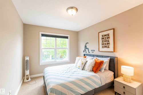 Carpeted room featuring a double-hung window, flush mount ceiling light, and neutral wall tones - 5092 Thibault Way Nw, Edmonton, AB 