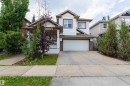Attached single-family residence with an integrated garage, covered front porch, and concrete driveway - 5092 Thibault Way Nw, Edmonton, AB 