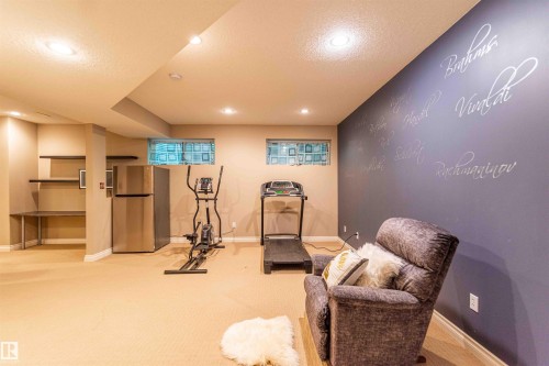 Recessed lighting, built-in shelving, durable carpeting, two basement windows, and a stainless steel refrigerator - 5092 Thibault Way Nw, Edmonton, AB 