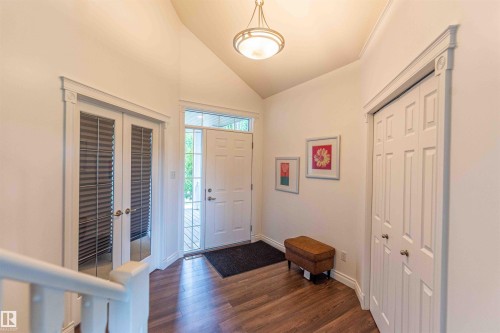 Welcoming foyer showcasing hardwood flooring, recessed ceiling lighting, and multiple closet storage options - 5092 Thibault Way Nw, Edmonton, AB 
