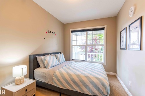 Carpeted flooring, neutral wall tones, and a window with white trim - 5092 Thibault Way Nw, Edmonton, AB 