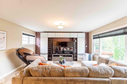 Built-in media center with shelving, recessed lighting, and wall-mounted sconces - 5092 Thibault Way Nw, Edmonton, AB 