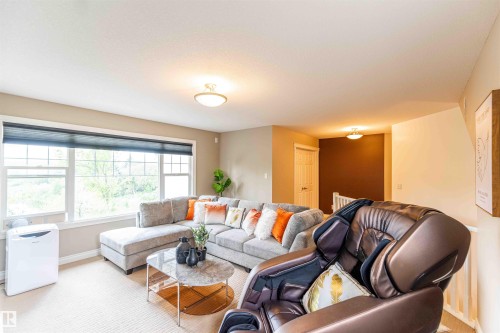 Spacious room with large windows, neutral wall tones, and ceiling-mounted lighting fixtures - 5092 Thibault Way Nw, Edmonton, AB 