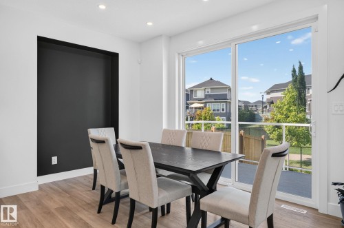 Spacious interior featuring wood-finish flooring, recessed lighting, and a built-in wall niche with a dark accent wall - 16304 19 Avenue Sw, Edmonton, AB 