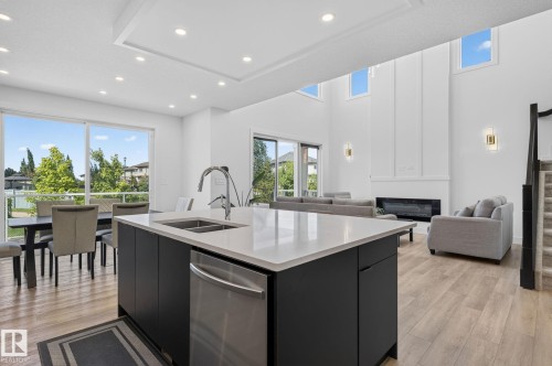 Kitchen island with an undermount double-basin sink and stainless steel dishwasher - 16304 19 Avenue Sw, Edmonton, AB 
