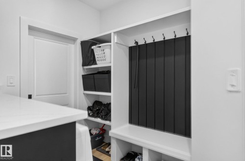 Built-in mudroom organization featuring bench seating, storage cubbies, shelving, and wall hooks - 16304 19 Avenue Sw, Edmonton, AB 